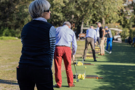 Pratiquer des swings de golf ; balles alignées sur des tapis.